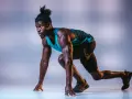 Sprinter w pozycji startowej, gotowy do biegu. Zastanawiasz się, ile biega najszybszy człowiek na świecie?