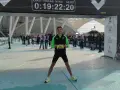 Uśmiechnięty Dariusz z numerem 1360 na piersiach po biegu na maratonie Valencia. Czas na tablicy: 0:19:22:20.