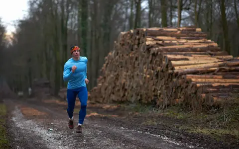 Biegacz w lesie, obok stosu drewna, czerpie siły z czystego powietrza. To jego strefy tlenowe.